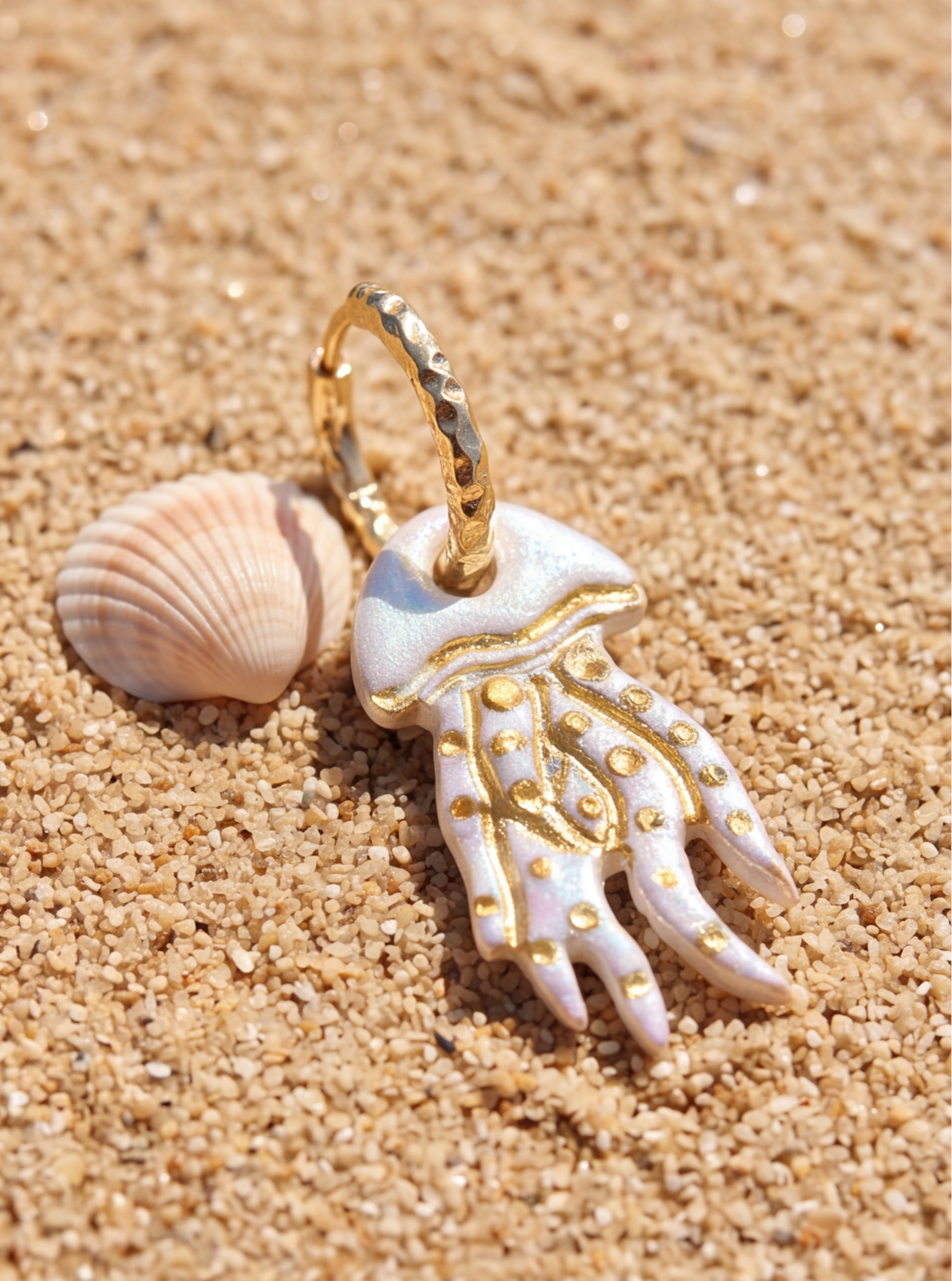 boucle d'oreille mesure, étincelante, sur le sable